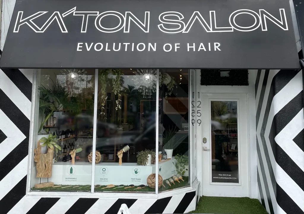 Storefront of Ka’ton Salon with black and white striped exterior decor and a display window showing products for a haircut. - Ka'ton Salon, Fort Lauderdale FL