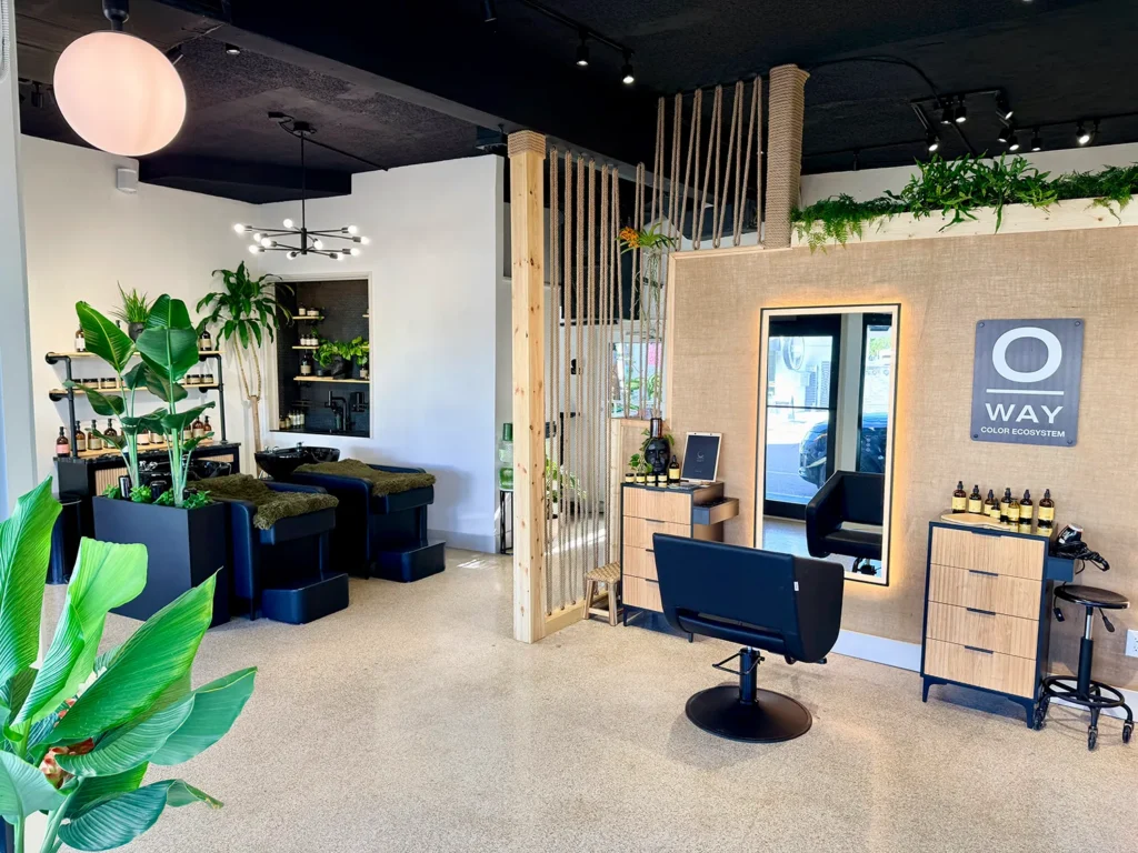 Interior of a hair salon with two shampoo stations and a styling chair facing a mirror, featuring Oway signage on the wall for a professional hair stylist environment. - Ka'ton Salon, Fort Lauderdale FL